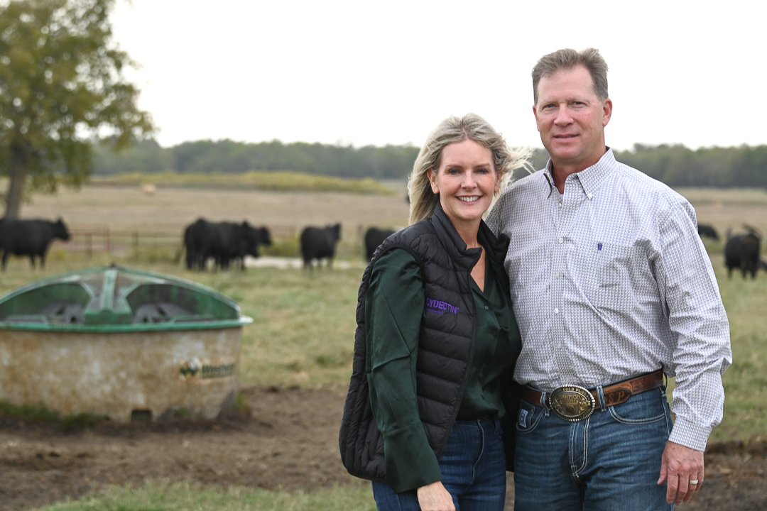 couple standing in front of cattle and lick tank